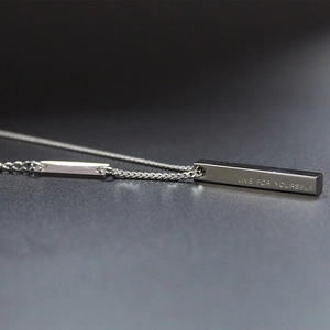 Polished silver bar pendant necklace engraved with Live For Yourself on dark background