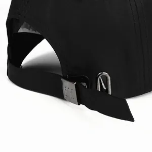 Detail of adjustable metal buckle with DI engraving on black cotton baseball cap