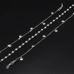 Chaîne de lunettes argentée avec perles blanches et pendentifs coquillages sur fond noir