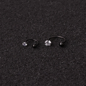 Close-up of black C-shaped surgical steel nose studs with sparkling clear zircon stones