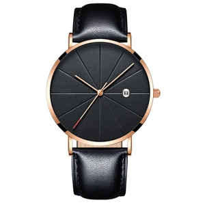 Detail of rose gold watch case with black dial and leather strap showing date window
