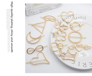 Detailed close-up of various gold alloy hair clips in heart, star, and crown shapes