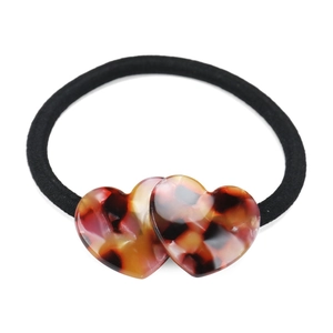 Macro detail of elastic hair tie with dual tortoiseshell resin heart charms and black cord