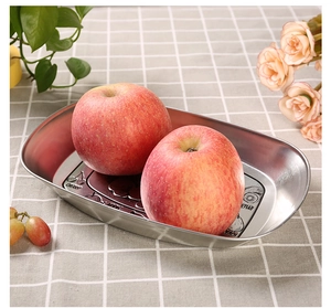 Detail view of a vintage rectangular tin plate with fruit patterns and two fresh apples
