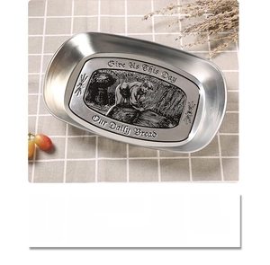 Detail of vintage tinplate fruit tray with embossed pastoral scene and daily bread text