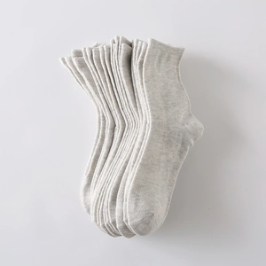 Detail showing the fine knit texture and soft fabric of stacked light grey cotton socks