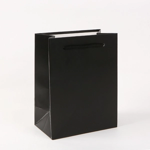 Detailed view of a black cardboard gift bag with durable matching rope handles