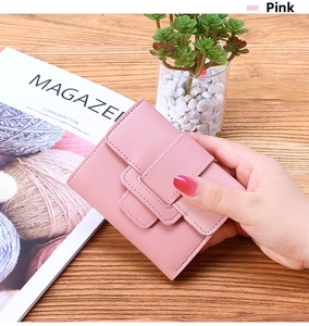 Detailed close-up of a pink tri-fold wallet with fine textured finish and snap closure