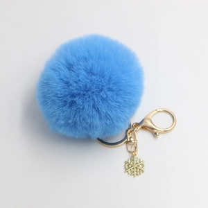 Blauwe pluizige pompon sleutelhanger met gouden sneeuwvlok hanger voor tassen