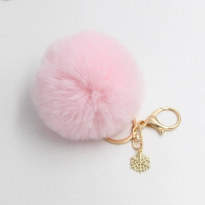 Nahaufnahme vom rosa Plüsch-Schlüsselanhänger mit goldener Schneeflocke und Karabiner