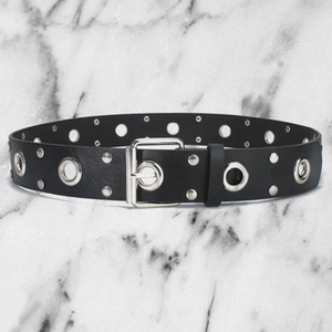 Close-up of black PU leather belt with silver metal eyelets, studs and a rectangular buckle