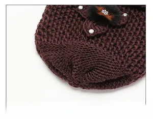 Detail of winter knit hat with a floral ornament and secure top stitching for durability