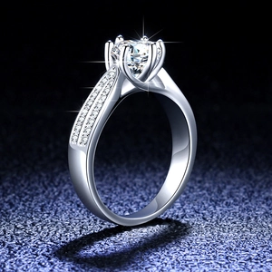 Macro shot of silver moissanite ring with six-prong setting and side accent stones