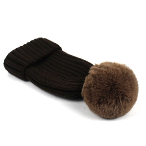 Detailed close-up of dark brown knit beanie texture with large light brown faux fur pompom