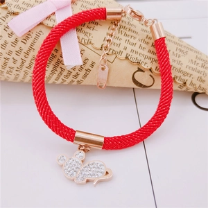 Detail of red braided rope bracelet featuring a rose gold mouse pendant with rhinestones