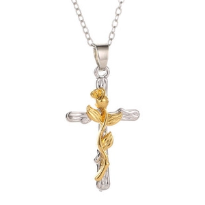 Macro detail of silver cross pendant with gold embossed rose and delicate link chain