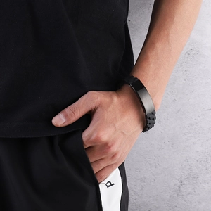 Bracelet sport en silicone pour homme avec plaque en acier inoxydable sur fond de mur gris