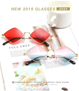 Detail of rhombic vintage sunglasses with gold metal frames in red and gradient lenses