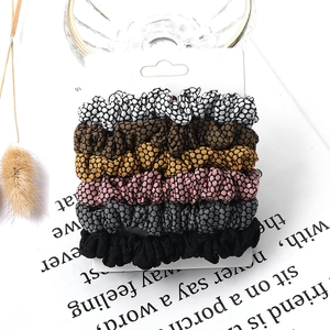 Set of 6 honeycomb textured fabric hair scrunchies in assorted neutral colors on a card