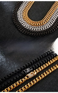 Detail of stainless steel Cuban link chains in gold, silver and black with stone settings