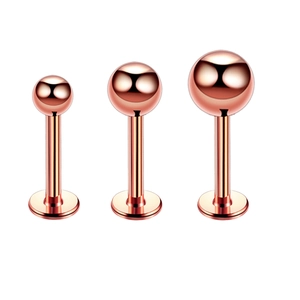 Detailed view of three rose gold stainless steel labret studs with spherical ends
