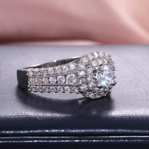 Macro side view of a luxury pavé-set silver engagement ring with large round solitaire stone