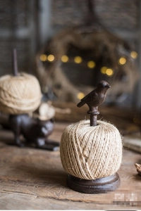 Detail of vintage cast iron twine holder with bird ornament and natural jute rope spool