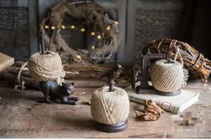 Close-up of vintage cast iron twine holders with cat bird and sewing machine designs