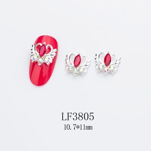 Détail du bijou d'ongle ailes de couronne avec gemme marquise rouge et cristaux aurora