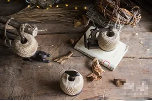 Close-up of vintage cast iron twine holders with cat, bird, and sewing machine motifs