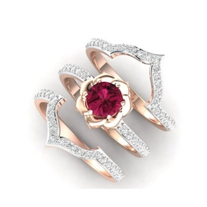 Three-piece rose gold ring set featuring a floral red stone center and V-shaped bands
