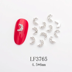 Detailed view of 4.5x6mm moon-shaped silver nail gems with pearls on red manicure