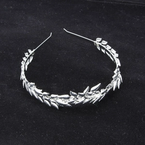 Detail of silver leaf headband showing delicate metal branches on velvet background