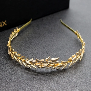 Close-up of golden metal leaf headband with fine textures on a dark background