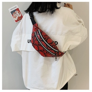 Detail of red snake pattern texture on women's waist bag with double zipper closure