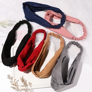 Set of 6 solid color twisted elastic headbands in various tones on a stylish background