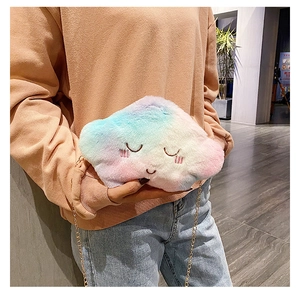 Detail of plush cloud-shaped rainbow crossbody bag with gold chain strap on model