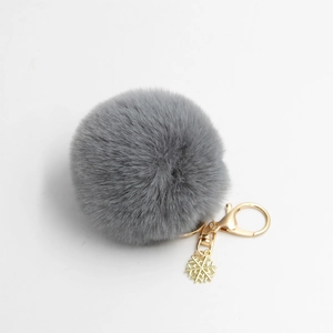 Grauer flauschiger Kunstpelz-Schlüsselanhänger mit goldenem Karabiner und Schneeflocke