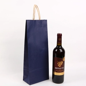 Dark blue kraft paper wine gift bag with sturdy handle shown beside a red wine bottle