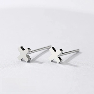 Macro view of minimalist 4x4mm stainless steel X-shaped stud earrings in steel color