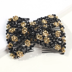 Detailed view of handmade black and gold beaded magic hair comb with a bow design