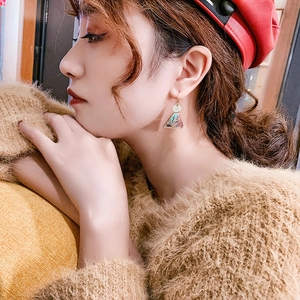 Detail view of triangular geometric earrings with vintage floral pattern on model