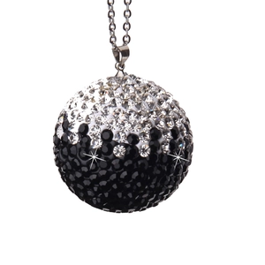 Close-up of sparkling black and white gradient crystal ball pendant with silver chain
