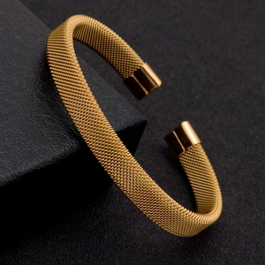 Détail macro du bracelet jonc doré en maille d'acier inoxydable avec embouts lisses