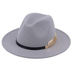 Detailed close-up of a grey wool fedora featuring a gold metal leaf and black band