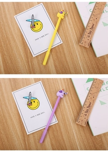 Close-up of cute elephant cartoon pens in yellow and purple on a wooden desk surface