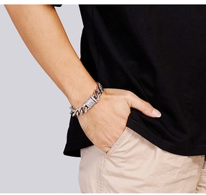 Close-up of polished silver Cuban link bracelet made of stainless steel on a male wrist