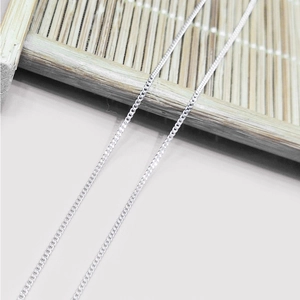 Close-up of S925 sterling silver curb chain links on a natural bamboo mat background