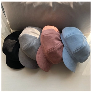 Detail shot of minimalist suede newsboy caps in black, grey, pink, and blue colors