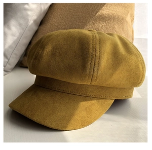 Macro detail of mustard yellow suede baker boy hat showing premium stitching and texture